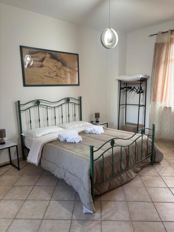 ein Schlafzimmer mit einem großen Bett mit weißer Bettwäsche in der Unterkunft La Finestra sul Teatro Romano in Benevento