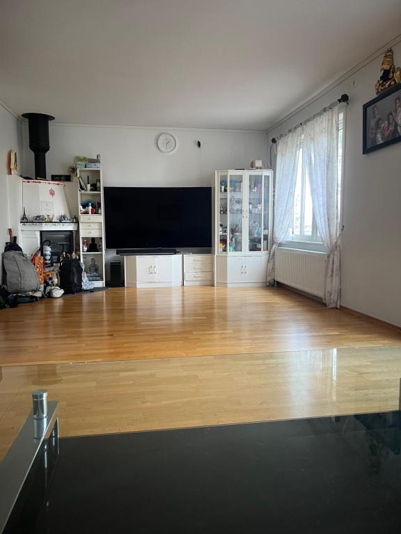 an empty living room with a large flat screen tv at Gamle bygdevei 198b in Oslo