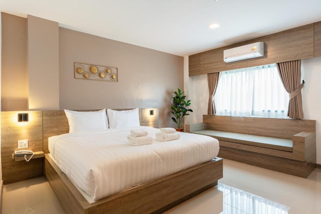 ein Schlafzimmer mit einem großen Bett, auf dem Handtücher liegen in der Unterkunft Finn Hotel in Ban Fang Daeng