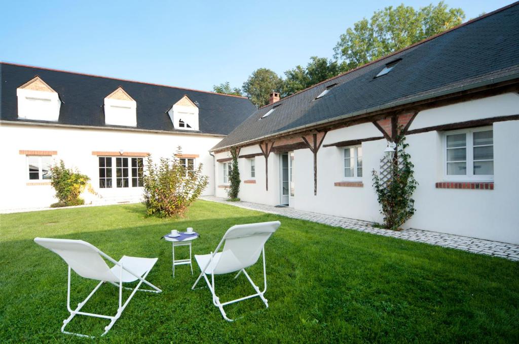 two chairs and a table in the yard of a house at Domaine de la Croix Tibi in Guilly