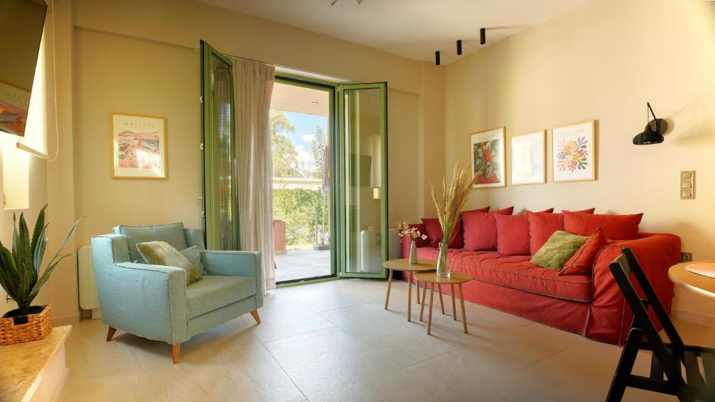 a living room with a red couch and a chair at Alkyoni luxury apartments Katakolo in Katakolon
