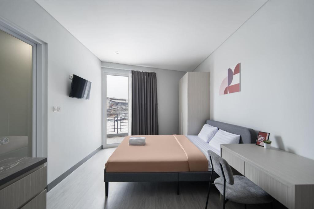 a small bedroom with a bed and a table at Cove Anasera in Jombang