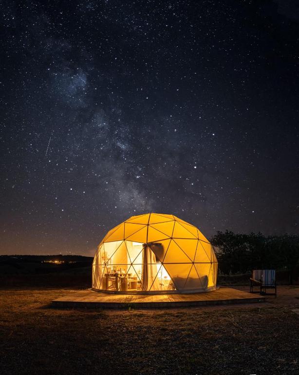 a large dome tent in a field at night at Cupola Geodetica in Paganico