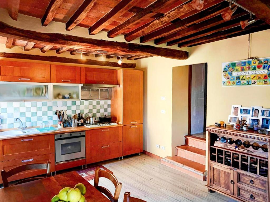 una grande cucina con armadi in legno e tavolo di Casa Rosa a Vetriano
