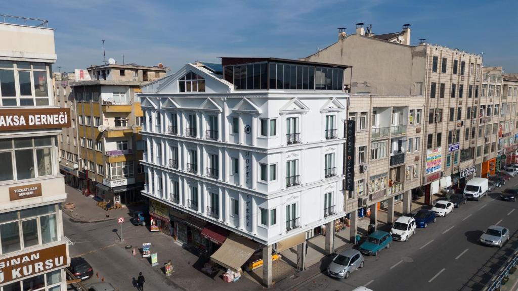 SteelOtel في قيصري: مبنى أبيض على شارع المدينة وبه مباني