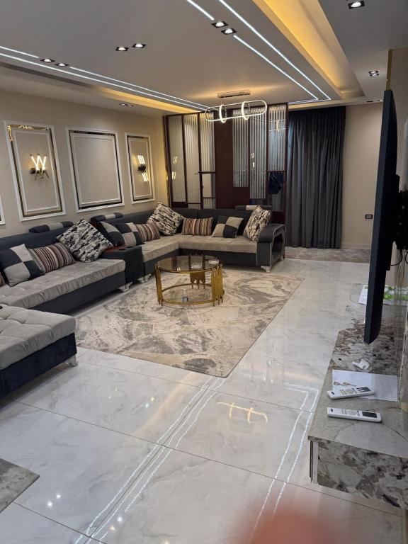 una amplia sala de estar con sofás y una mesa en ميدان لبنان المهندسين برج ابو الكرامات, en El Cairo