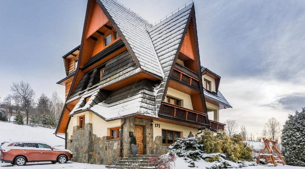 une maison avec une voiture garée devant dans l'établissement Pokoje Gościnne Chochołów, à Chochołów