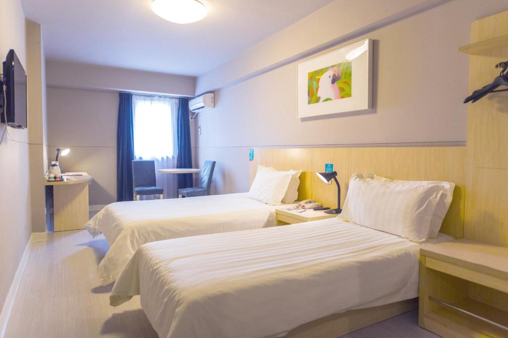 a hotel room with two beds and a window at Jinjiang Inn Select Harbin Linye University Wenchang Street in Harbin