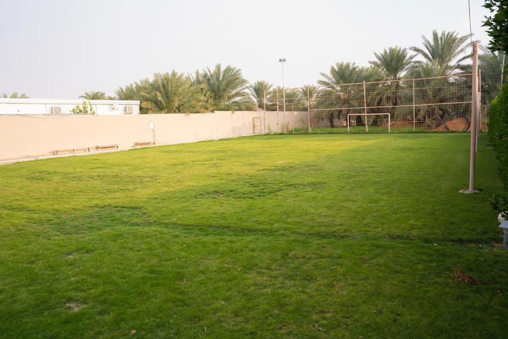 a soccer field with a fence and a soccer ball at مزرعة أبو رامي ملعب كرة قدم ومسبح وألعاب مائية ومجالس واسعة in Al Kharj