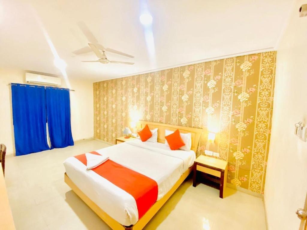 a bedroom with a large bed with blue curtains at THE CITY PARK HOTEl in Hyderabad