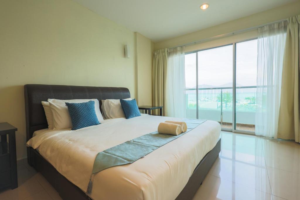 a bedroom with a large bed with a large window at Marina Island Lumut 3 Bedroom Holiday Apartment in Lumut