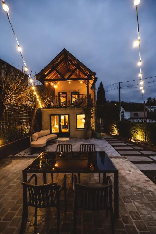 a patio with chairs and a table and a house at Twin Pines in Durbuy