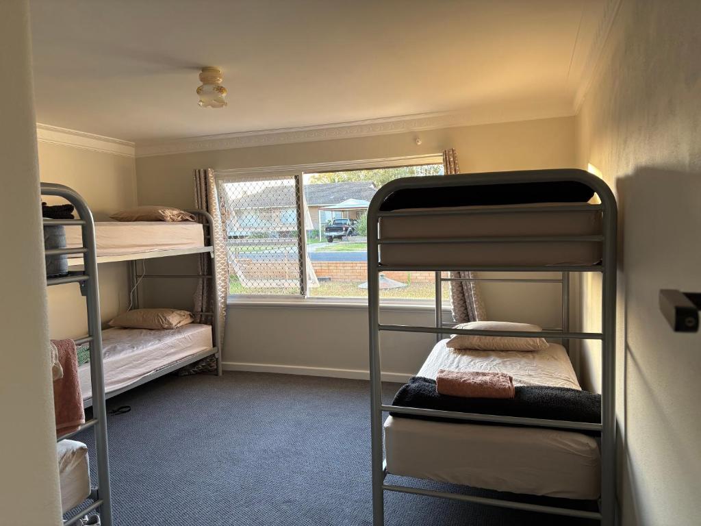 una habitación con dos literas y una ventana en 77 International Tourist House, en Mandurah