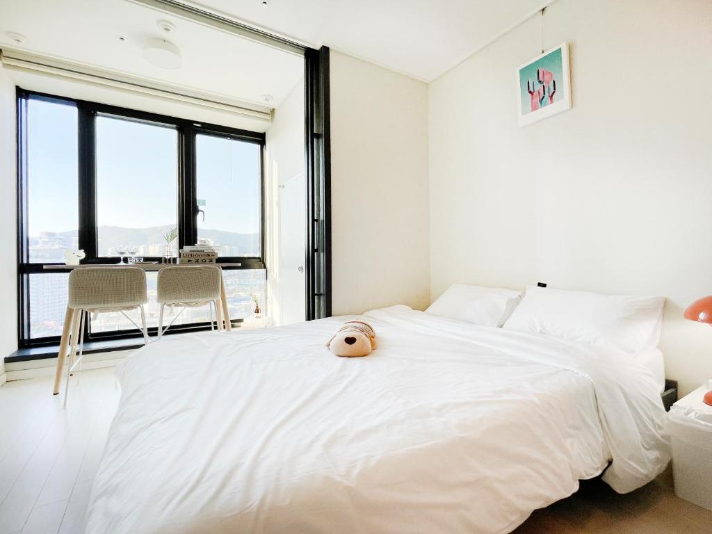 a bedroom with a white bed with a stuffed animal on it at 엠지스테이 서면 Mzstay Modern Hotel in Seomyeon in Busan