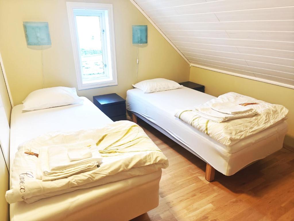 una habitación con dos camas y una ventana en Åkrehamn Marina, en Åkrehamn