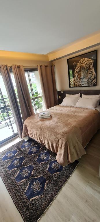 a bedroom with a large bed with a large window at Nany Vitrali Moema in São Paulo