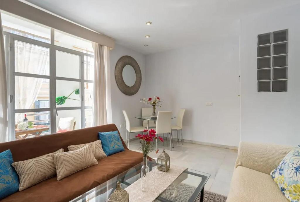a living room with a couch and a glass table at Charming Apartment in Malaga - 70 m² with Balcony in Málaga