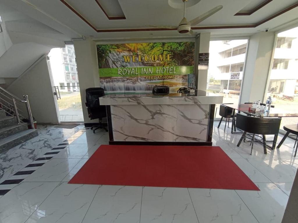 a lobby with a red carpet in a building at Royel IN Hotel in Mund Pīr Mahmūd