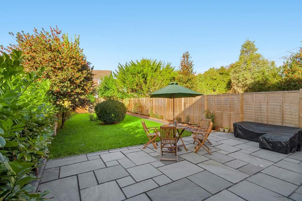 a patio with a table and chairs and an umbrella at Exeter Heights - Short Stays UK Ltd in Exeter