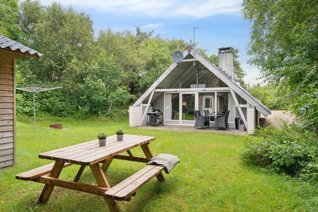 a picnic table in front of a small house at Feriehus 1133 in Ringkøbing