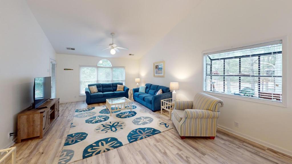 a living room with blue couches and a tv at Club Villas Unit 17D Villa in Sunset Beach