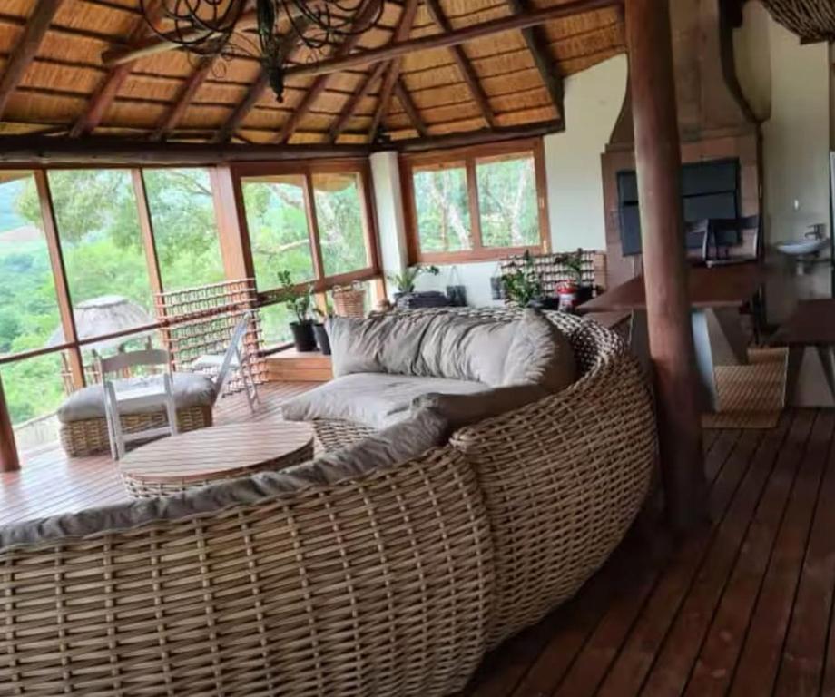 a living room with a large wicker couch on a wooden floor at RSM Country Estate Unit 2 in Nelspruit