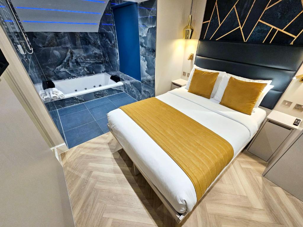 een slaapkamer met een bed en een badkamer met een bad bij Hotel London in Londen