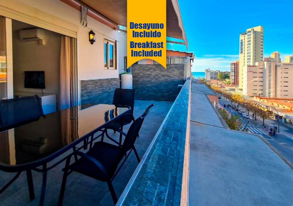 a balcony with a table and chairs on top of a building at Apartalux Ático Jaime I in Benidorm