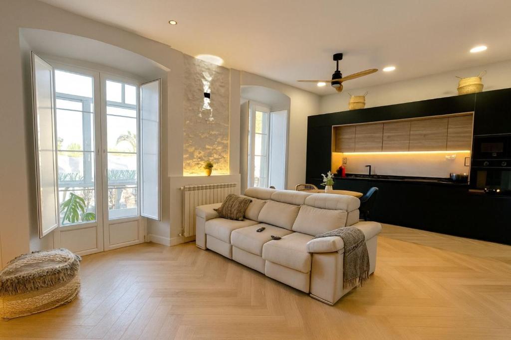 a living room with a white couch and a large window at alojamiento Premium Ribadesella Vistas al Mar in Ribadesella