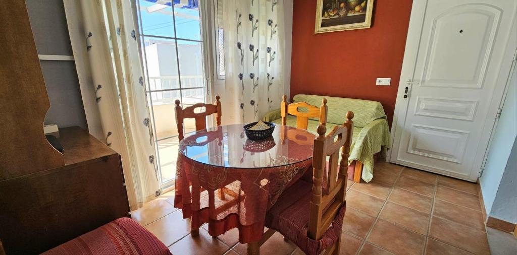 a dining room with a table and chairs and a window at Apartamentos Wily y Mavi in San José