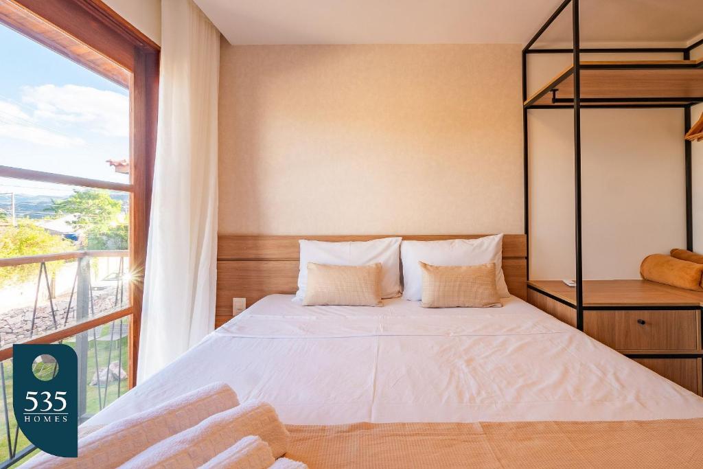 ムクジェーにあるFique em apartamento 2 quartos no centro de Mucugêの窓のある大きなベッドのある寝室