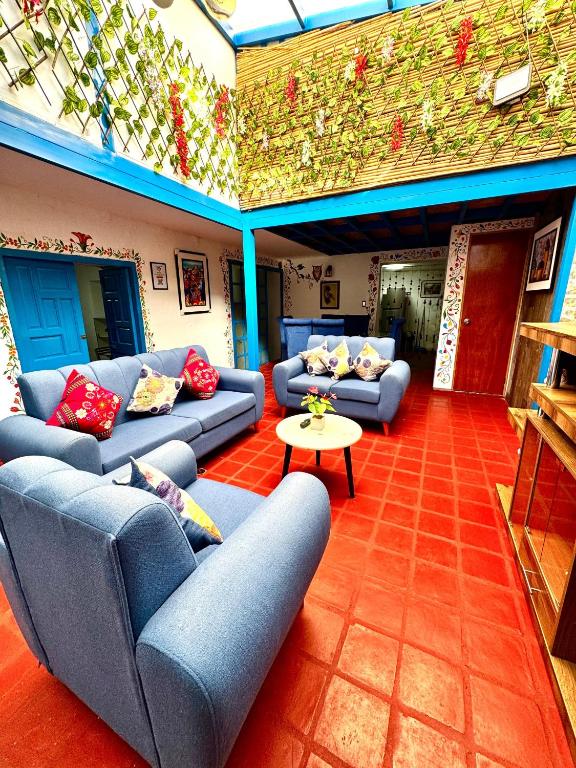 a living room with blue couches and a table at AITANA'S HOUSE - SAN BLAs in Cusco