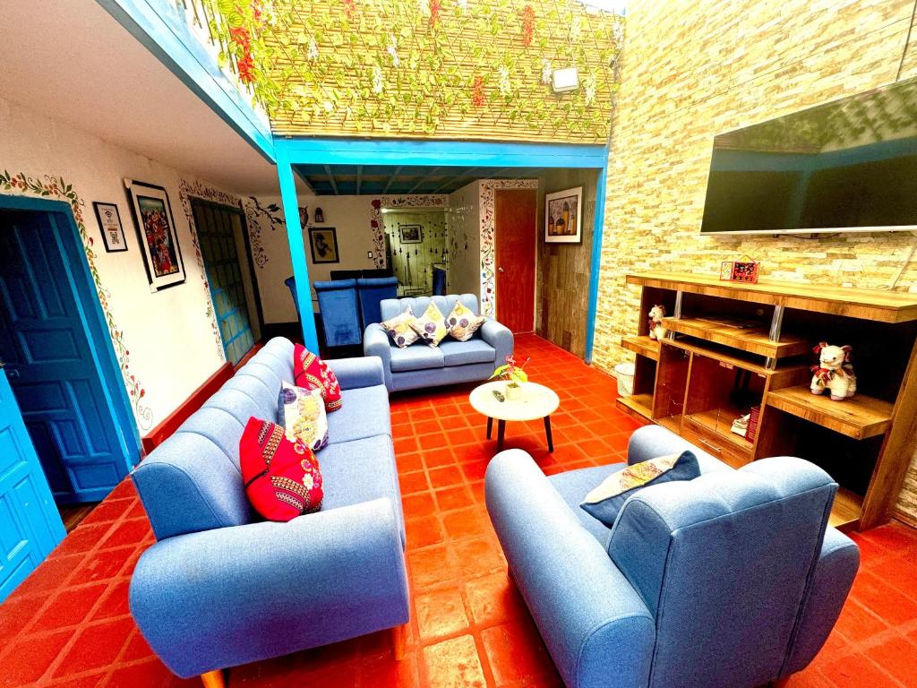 sala de estar con sofás azules y TV de pantalla plana en AITANA'S HOUSE - SAN BLAs, en Cusco