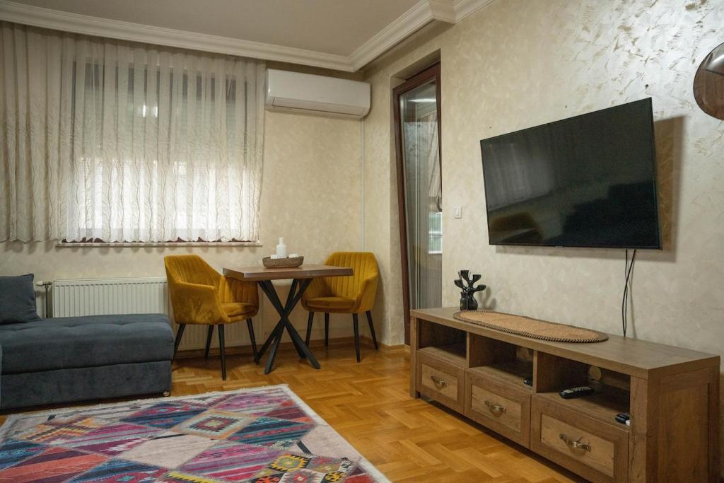 un soggiorno con un divano e una TV a parete di 111 Spot Apartment a Prizren
