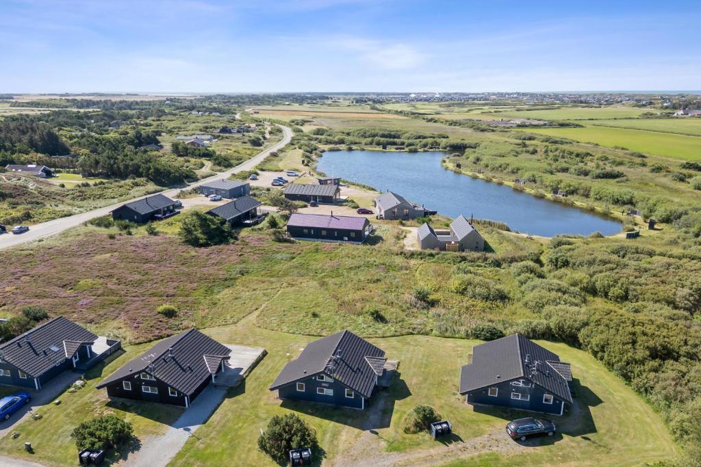 Feriehus 1143 في Nørby: اطلالة جوية على منزل مع بحيرة