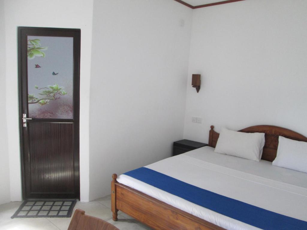 una camera con un letto e una porta con una finestra di Bay Reach Home Stay a Weligama