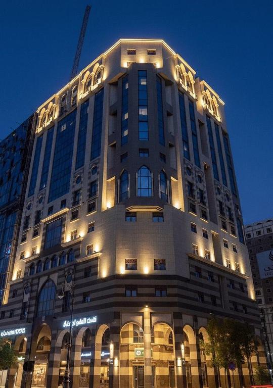 a large building with a crane on top of it at Al Ansar Platinum Hotel فندق الأنصار بلاتينوم in Medina