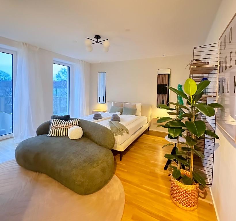 Modernes City Apartment inkl Garage und Balkon في لينز: غرفة معيشة بها أريكة وسرير ونبات