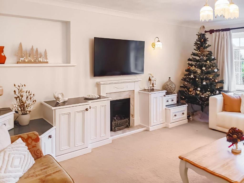 a living room with a fireplace and a christmas tree at Harbourside in Poole