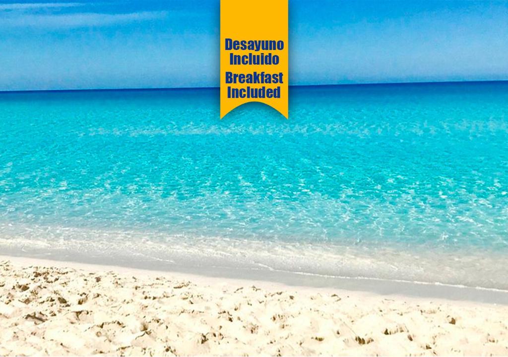 a yellow sign on the beach next to the ocean at Apartalux Villa Playa in Benidorm