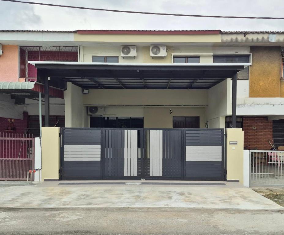 a garage with a black and white garage door at Hatasan Homestay Guess House in Perai