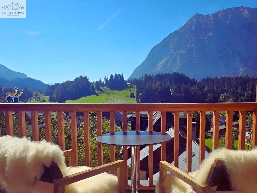 a dog sitting in a chair on a balcony with a table at Mountain Suite A10 - by FiS in Tauplitz