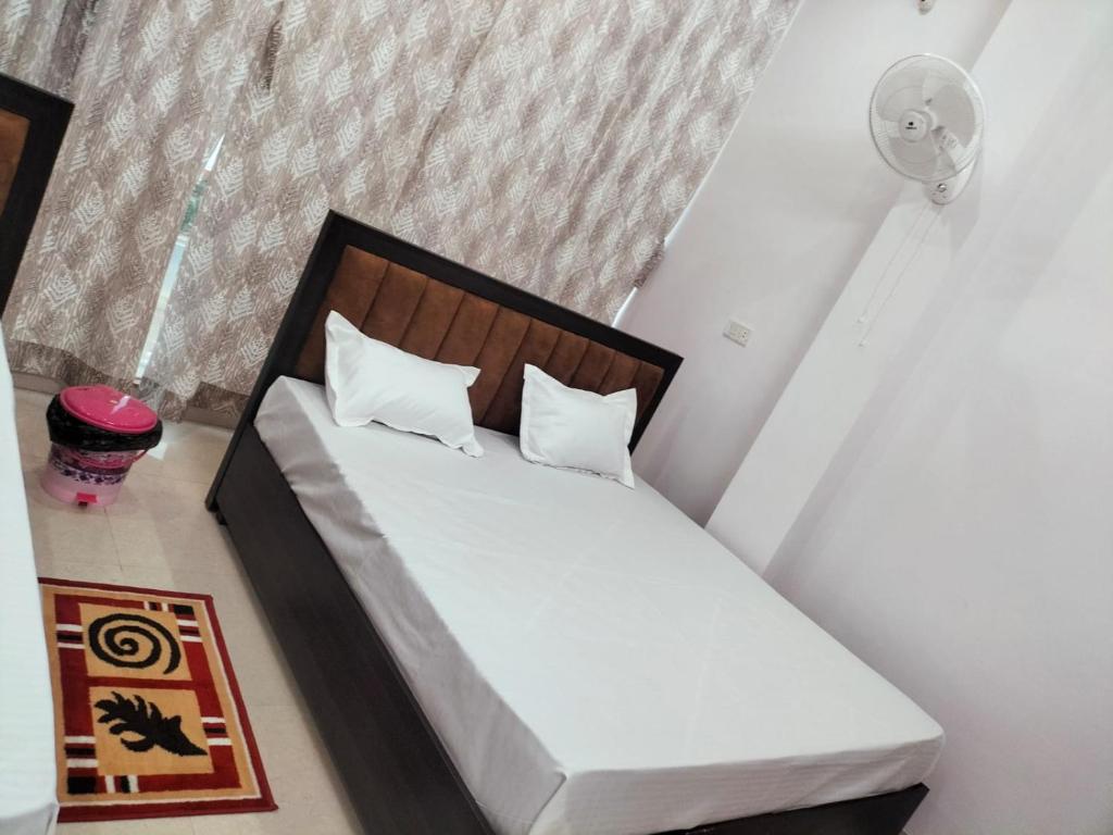 a bed with white sheets and pillows in a room at jp hotel and restorent in Rīngas