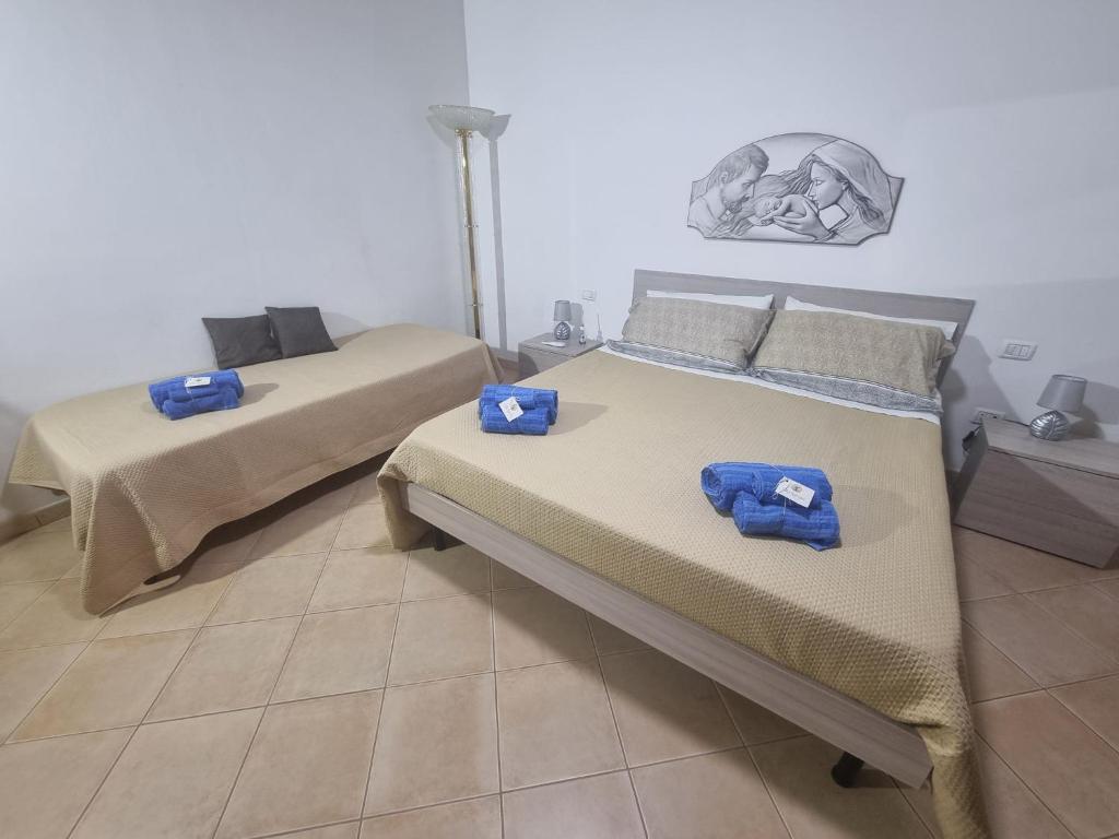 Dos camas en una habitación con toallas azules. en Villa Serroni Casa Vacanza, en Mazara del Vallo