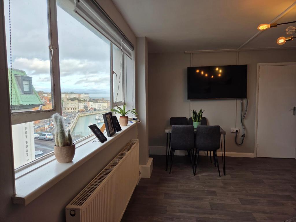 een kamer met een groot raam en een tafel met stoelen bij Marina Place in Ramsgate