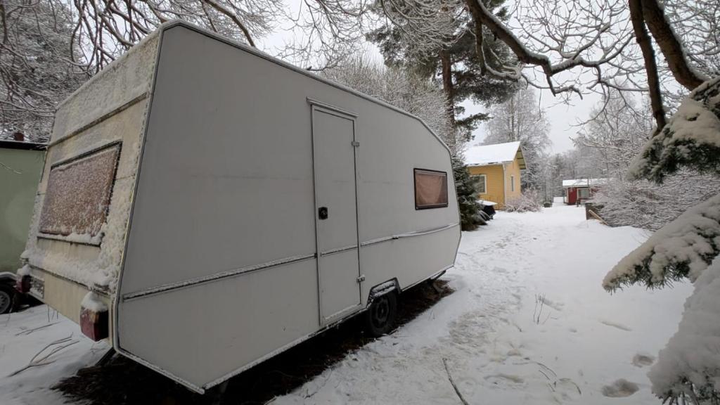 Ein weißer Anhänger steht im Schnee. in der Unterkunft Garden Caravan in Rovaniemi