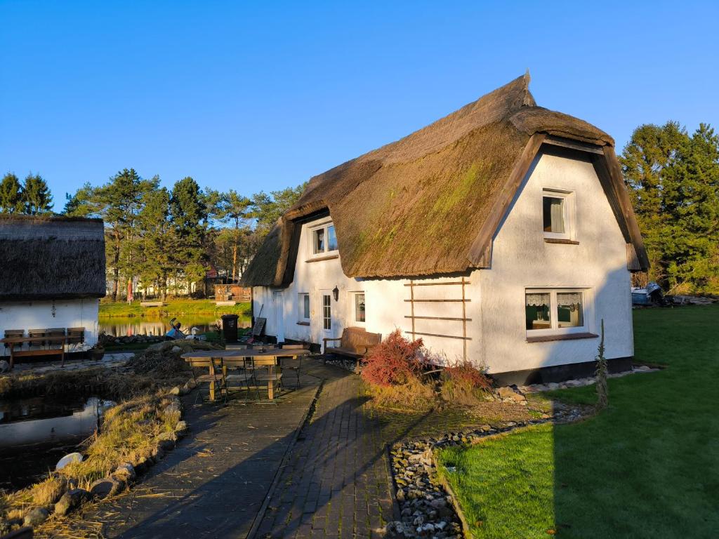 a thatched house with a picnic table in front of it at Schwanensee Ferienhaus in Göhren