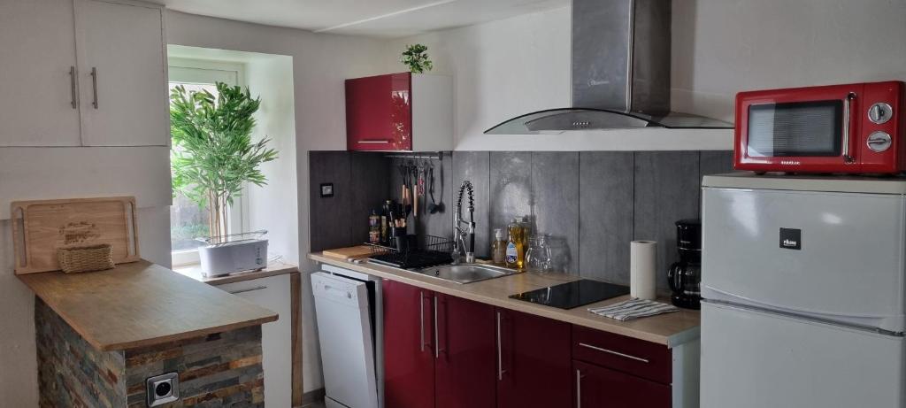 cocina con nevera blanca y microondas rojo en Maison proche Grand Parc 2 Chambres, en Mauléon