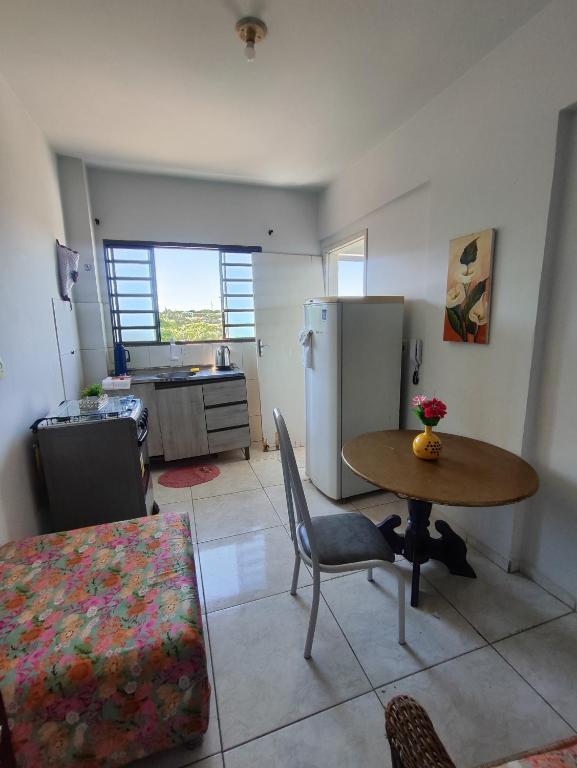 a kitchen and dining room with a table and a refrigerator at Apartamento Larah in Cianorte