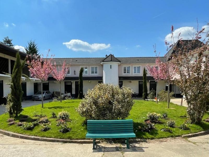 eine grüne Parkbank vor einem Gebäude in der Unterkunft Escapade Champêtre in Saint-Martin-en-Bière